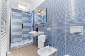 A modern bathroom with a glass shower enclosure, a sink, and a bidet. - AMORE RENTALS - Appartamento Tramontano with Air Conditioning and Internet WI-FI (Sorrento)
