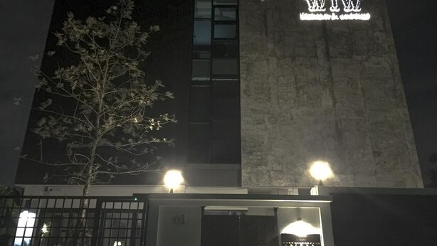 A modern building with a sign that reads "MINI HOTEL" and a tree in front. - WIW Minihotel (Bangkok)