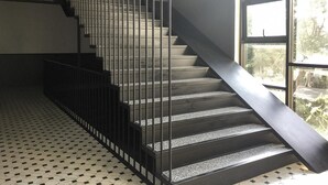 A staircase with metal railings and a patterned floor. - WIW Minihotel (Bangkok)