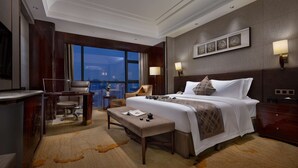 A hotel room with a large bed, a desk, a chair, and a view of the city. - Worldhotel Grand Jiaxing Hunan (Changsha)