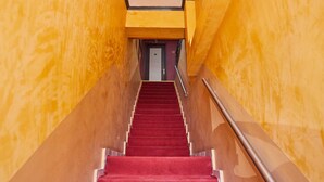 A staircase with red carpet leading to a door at the top. - Aegean Sea Rooms (Chios)
