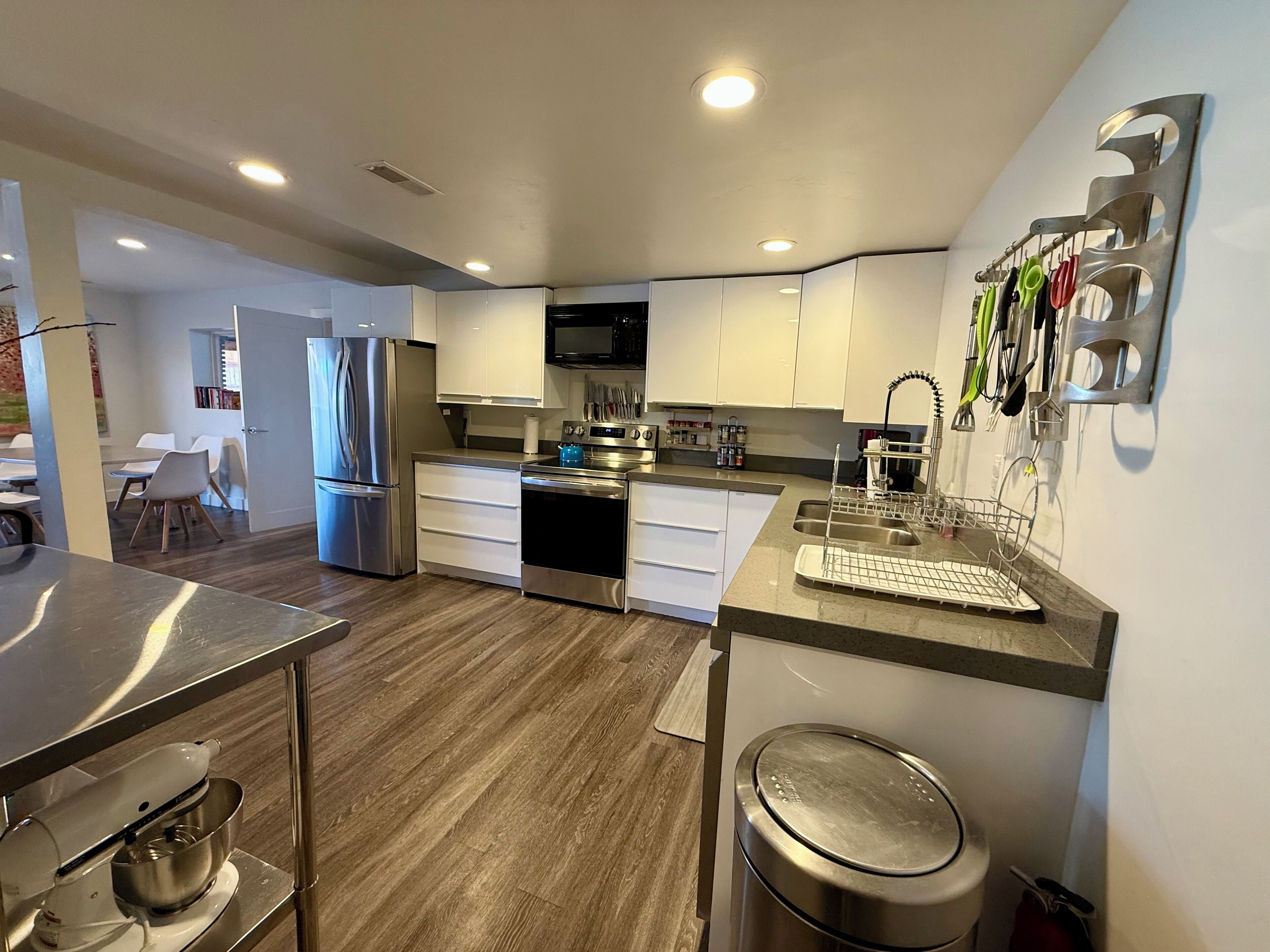 A modern kitchen with stainless steel appliances, white cabinetry, and a built-in microwave.