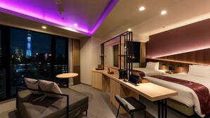 A modern hotel room with a city view, a desk, a bed, and a seating area. -  Henn na Hotel Premier Tokyo Asakusa Tawaramachi (Tokyo)