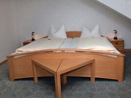 Ein Schlafzimmer mit einem hölzernen Bett, zwei Nachttischen und einem Beistelltisch.