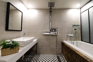 A modern bathroom with a white sink, a mirror, a shower, and a bathtub. - Brown Dot Daeyeon (Busan)