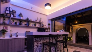 Une cuisine moderne avec un coin bar, des meubles en bois et une grande fenêtre.