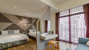 Une chambre moderne avec un grand lit, un bureau et un canapé.