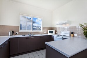 Apartamento, 4 quartos | Cozinha privada | Geladeira grande, micro-ondas, fogão, cooktop