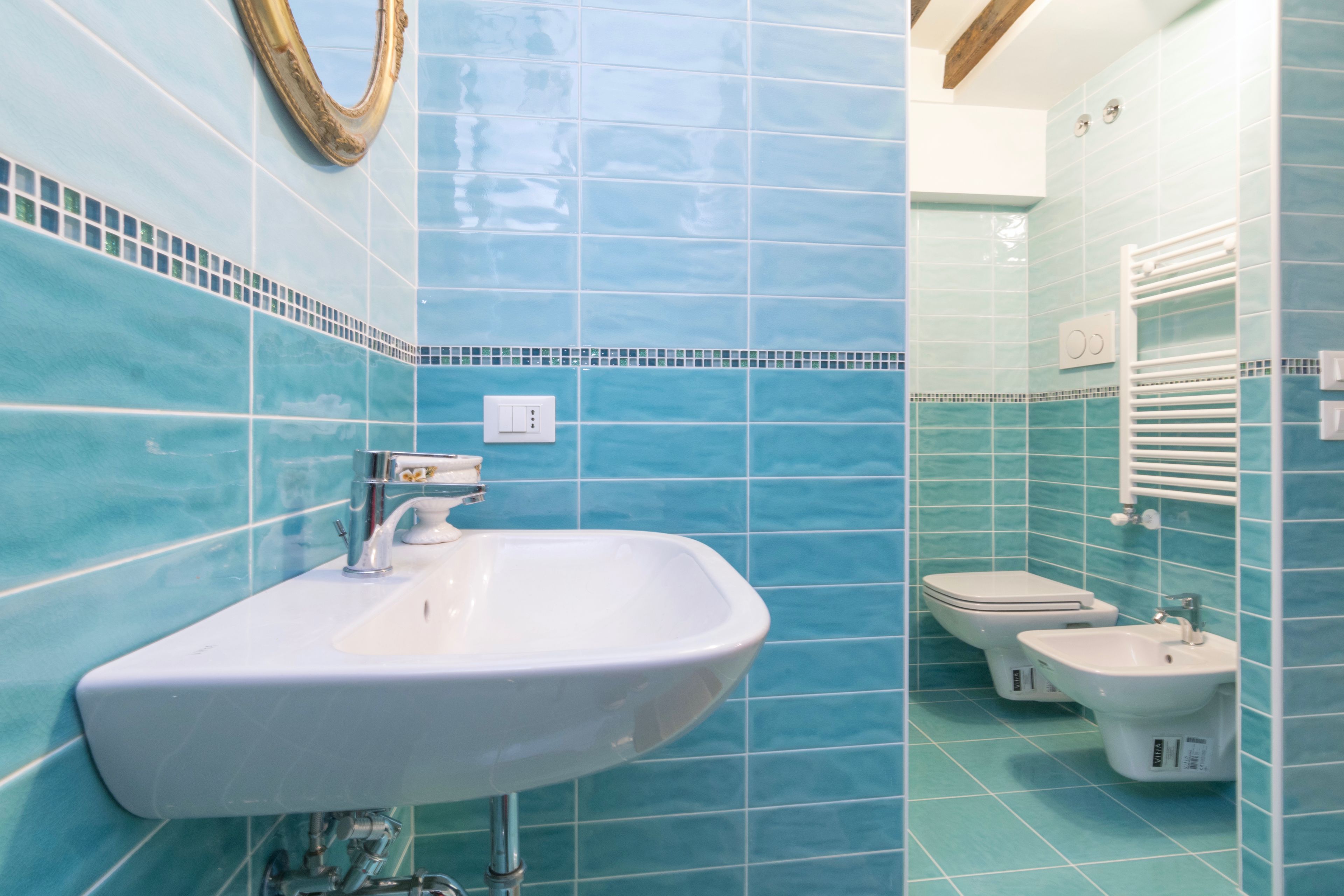 A bathroom with a sink, bidet, and toilet.