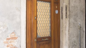 A wooden door with a glass panel, a metal handle, and a brass lock.