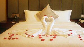 A hotel room with a neatly made bed, a pillow, and a wall-mounted painting. - Changsha Jiaxing Inn (Changsha)