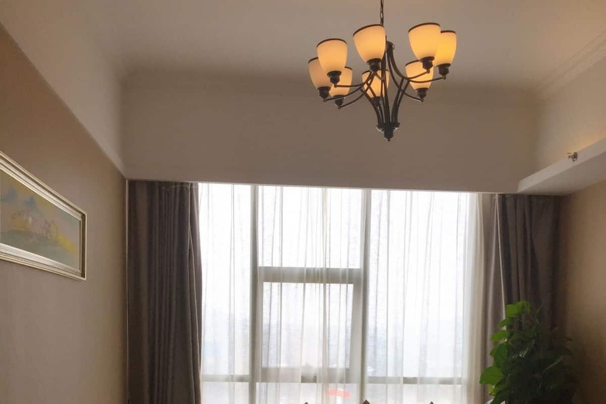 Habitació d'hotel amb un llit gran, un sofà, una taula de menjador i un penjador.