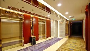 A hotel corridor with elevators, a patterned carpet, and a wooden floor. - Changsha Jiaxing Inn (Changsha)