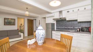 A modern kitchen with white cabinets, a stainless steel refrigerator, and a tiled backsplash. - Ca' Alberto Apartments 2 (Venice)