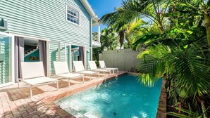A swimming pool with lounge chairs, a house with light blue siding, and tropical vegetation. - **SUMMER SOLSTICE @ OLD TOWN** 9BR Compound + Last Key White Glove Service... (Key West)