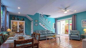 A living room with a dining area, a staircase, and a view of the outdoors. - **SUMMER SOLSTICE @ OLD TOWN** 9BR Compound + Last Key White Glove Service... (Key West)