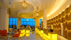 A lobby with a reception desk, seating area, and large windows. - Zina Beach Resort & SPA (Abdelmalek Ramdane)