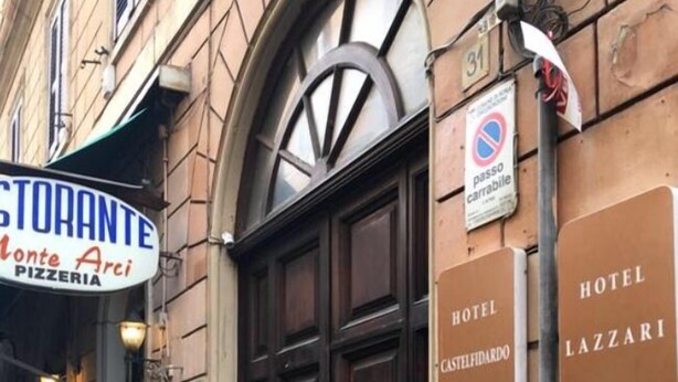 Ein Gebäude mit einem Schild für das 'Hotel Lazzari' und einer Pizzeria namens 'Monte Arci'.