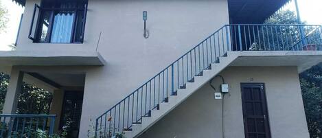 A two-story building with a staircase leading to a balcony.