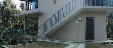 A two-story building with a staircase leading to a balcony.
