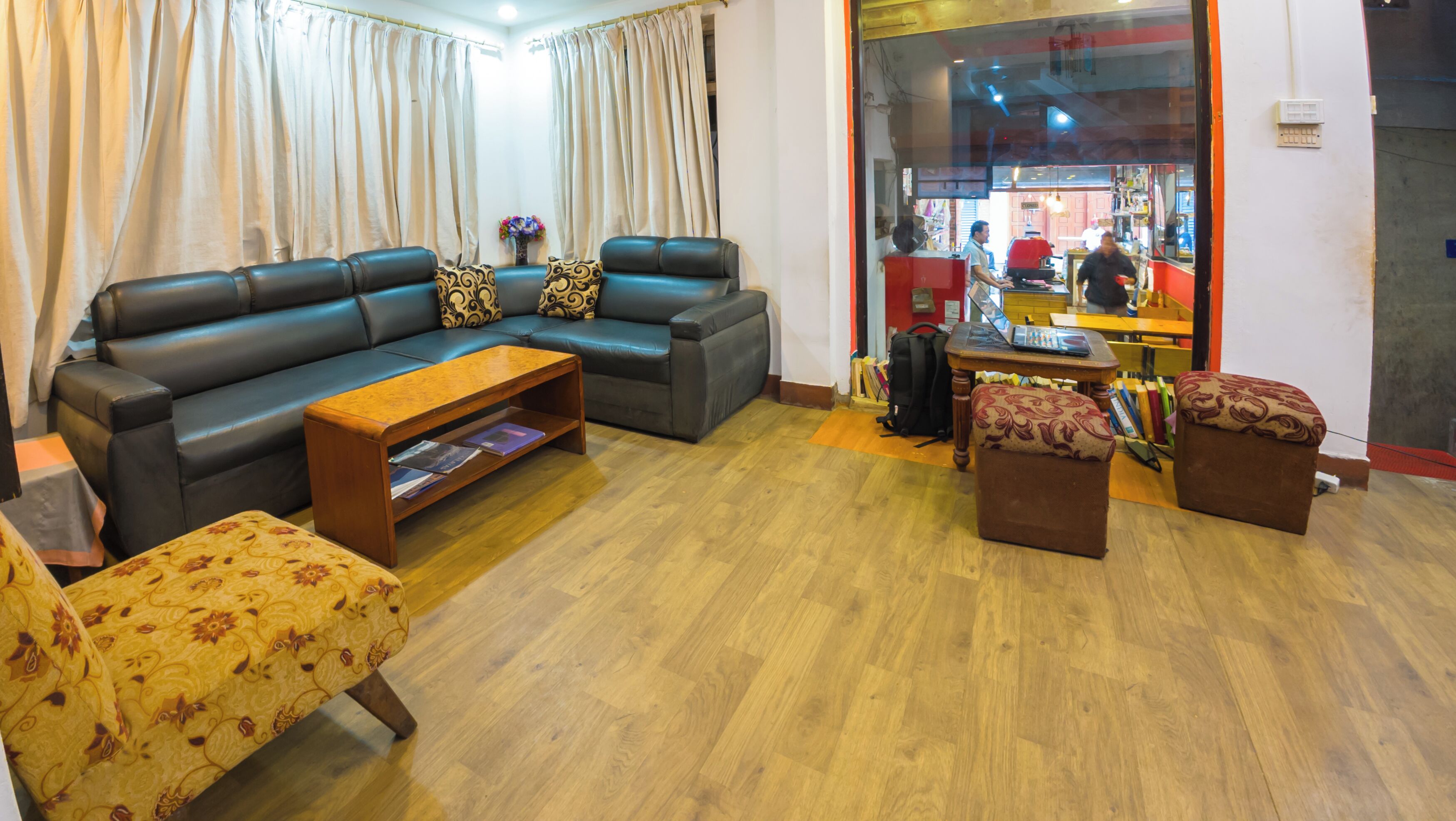 A living room with a sofa, coffee table, ottoman, and a patterned armchair.