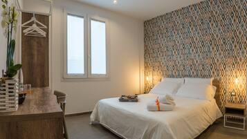 A bedroom with a bed, bedside table, and a dresser with a mirror.