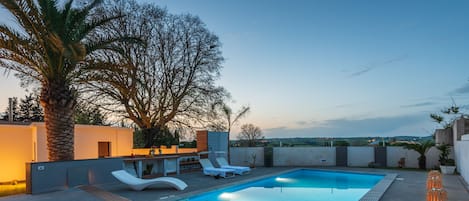Piscine extérieure en saison, chaises longues