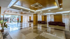 A spacious lobby with a polished floor, large seating area, and a view of the outdoors.