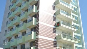 A high-rise building with multiple balconies and a modern architectural design.