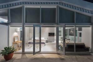 A modern bedroom with a large bed, a bedside table, and a TV. - TG Hostel (Taichung)