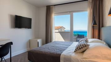 Deluxe dubbelrum eller tvåbäddsrum - havsutsikt | Värdeförvaringsskåp på rummet, skrivbord och mörkläggningsgardiner