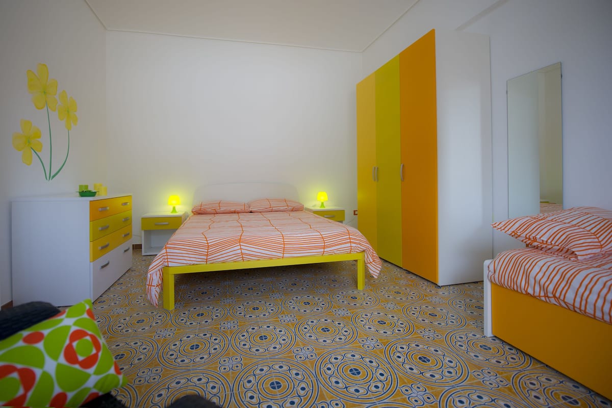 Une chambre à coucher avec un lit, des tables de chevet, une armoire et un miroir.