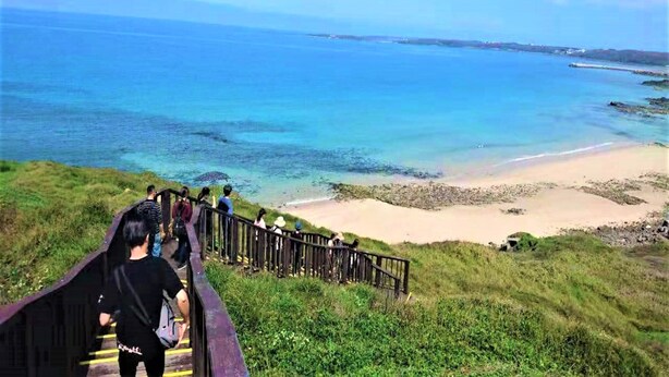 A wooden staircase leading to a beach with clear blue water and a sandy shore. - Starrysky Family (Magong)
