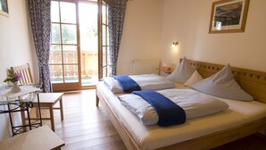A bedroom with a wooden bed, a desk, and a chair.