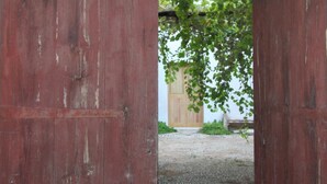 An arched wooden door leading to a cobblestone path. - Agriturismo Castelluzzo (Custonaci)