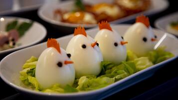 A dish with egg-shaped items topped with carrot-like decorations, served on a bed of lettuce.