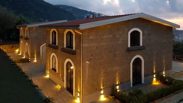 A two-story building with arched windows and a red-tiled roof. - Maison Bon Bon (Sorrento)