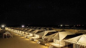 A row of tents with a starry night sky in the background. - Aroma Desert Safari Camp (Jaisalmer)