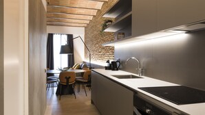 Eine moderne Küche mit Einbauherd, Spüle und Essbereich mit Stühlen und Tisch.