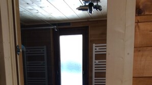 Ein Holzinnenraum mit Fenster, Tür und Fliesenboden.