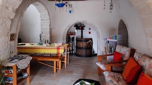 Ein gemütliches Interieur mit einem Holztisch, Stühlen, einer Couch und einem Bücherregal.