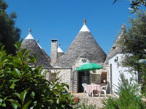Charming cottage with a patio area, perfect for outdoor dining or relaxation, amidst a serene village setting.