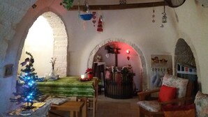 Ein gemütliches Interieur mit einem Esstisch, Stühlen, einer kleinen Weihnachtstanne und einem Kamin.