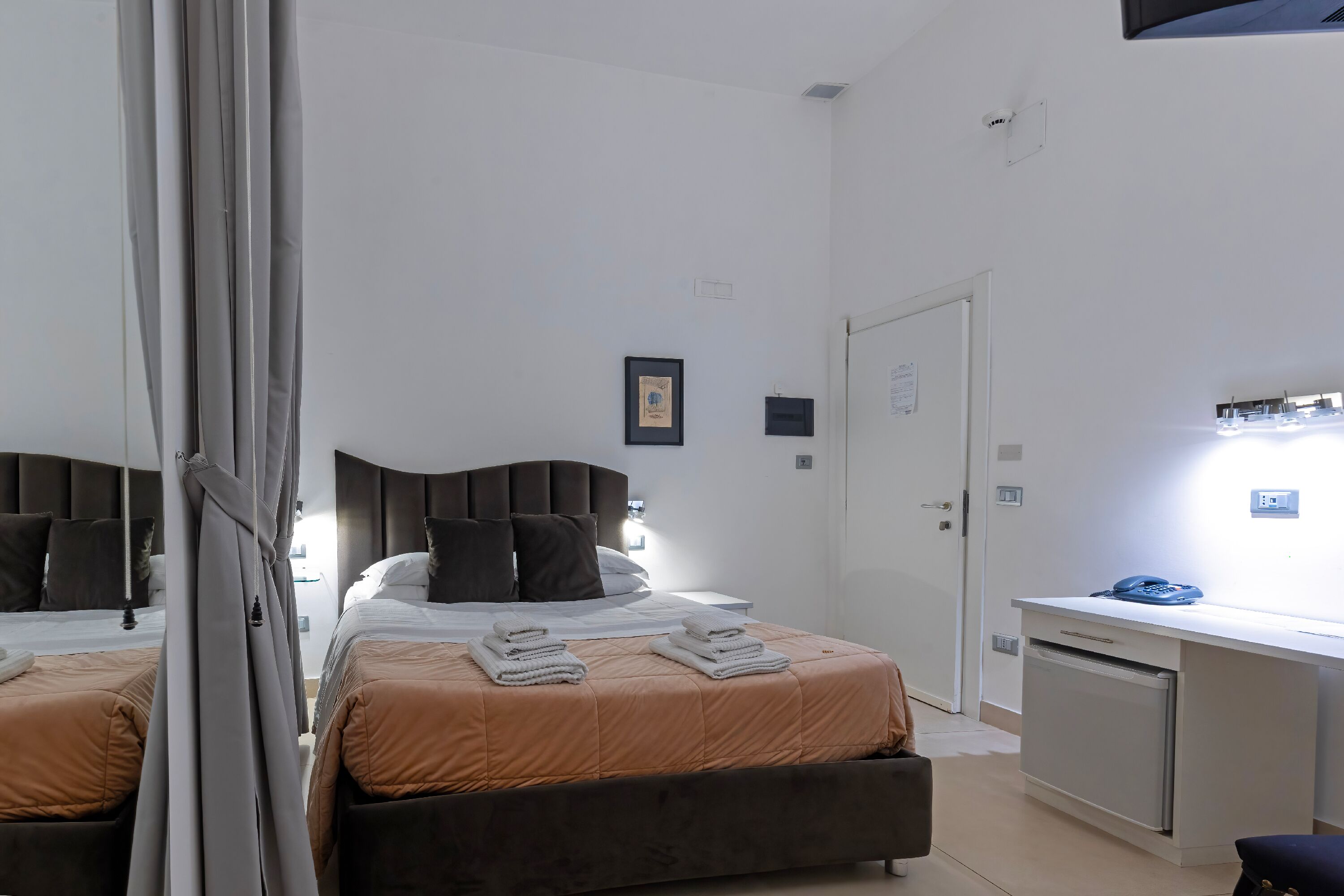 Een slaapkamer met twee bedden, een bureau en een kledingkast.