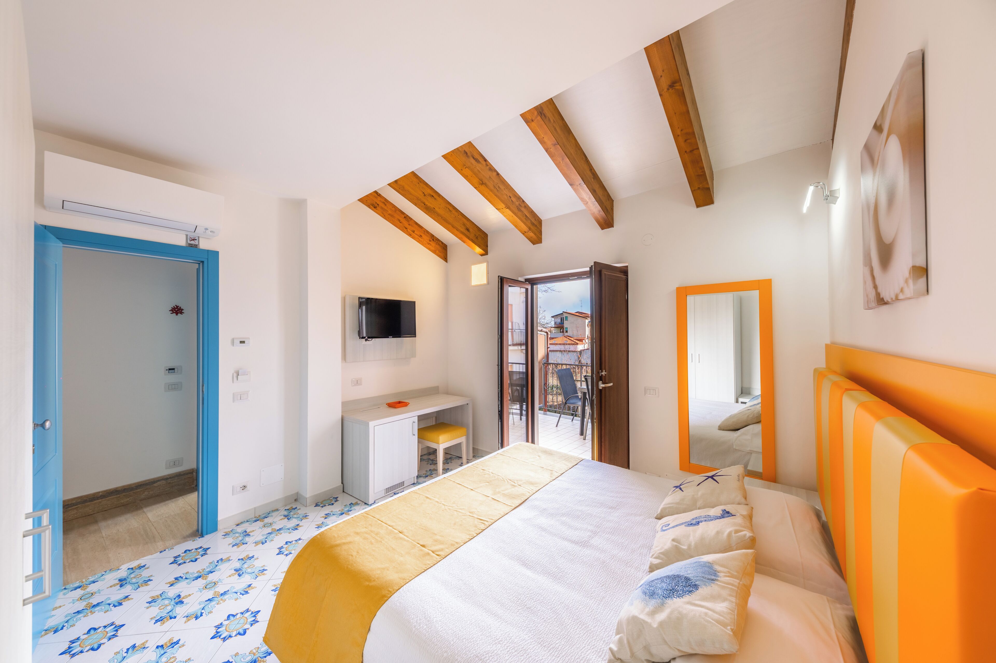 Een slaapkamer met een bed, bureau en televisie.