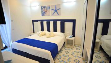 A hotel room with a bed, bedside tables, a telephone, and a mirror.