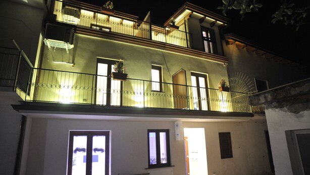 Un immeuble de deux étages doté de balcons, de grandes fenêtres et d’une porte donnant sur une entrée abritée.