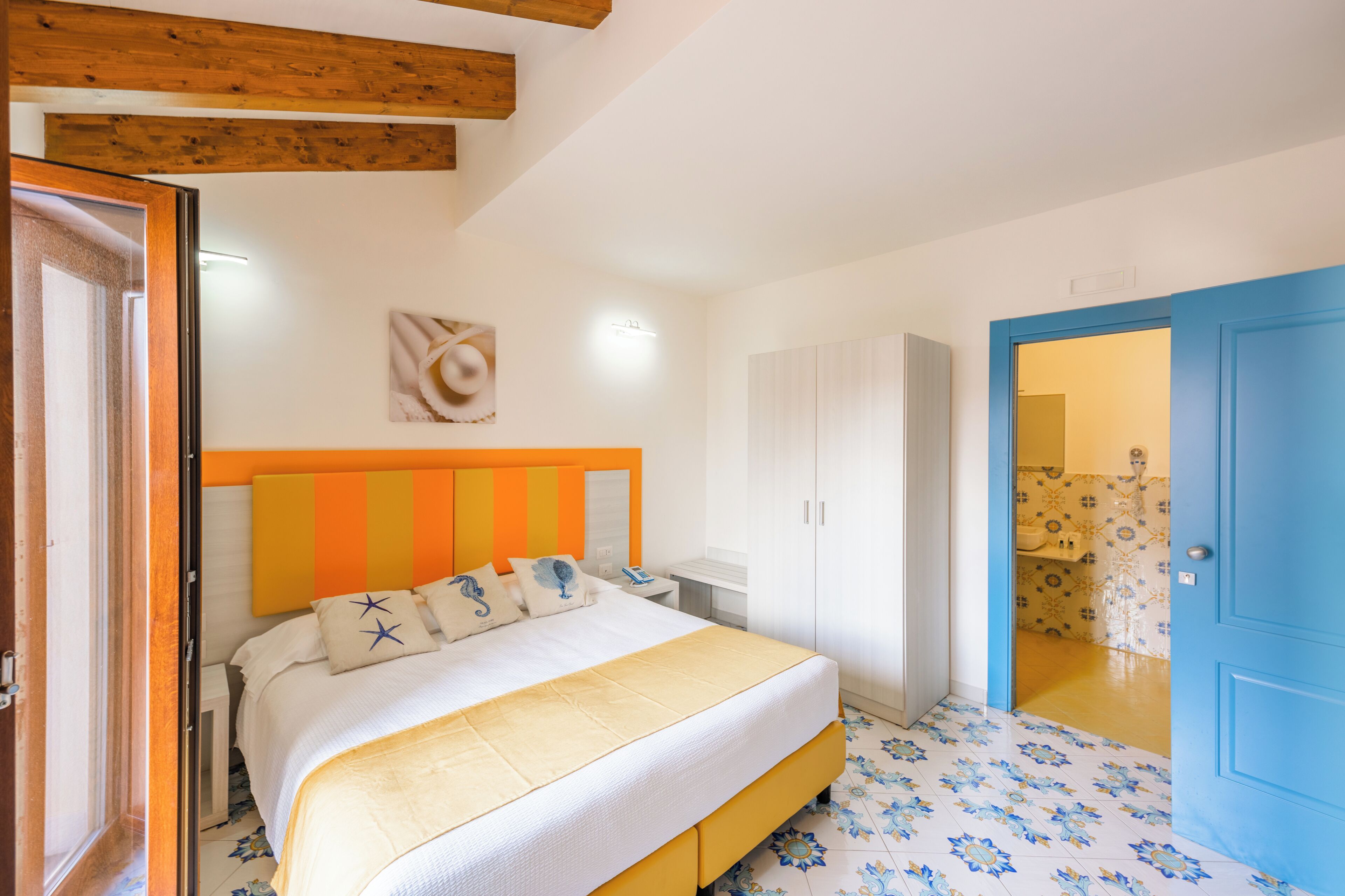 Un dormitorio con una cama, un armario y un baño visible a través de una puerta abierta.