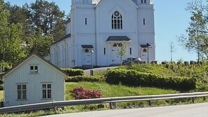 A church with two towers and a smaller building in front. - Idyllic southern country house in Risør (Risør)