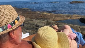 A person lying on rocks by the sea, wearing a straw hat. - Idyllic southern country house in Risør (Risør)